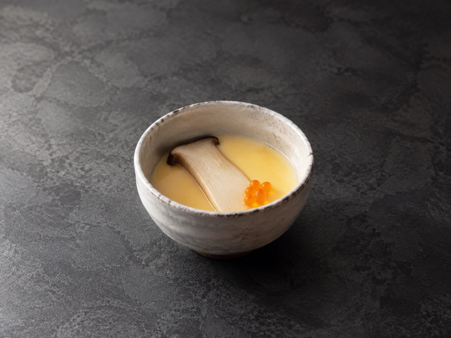 Chawanmushi com cogumelo eryngui e ovas de truta em pequena tigela artesanal.