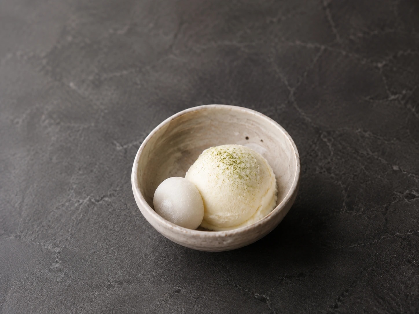 Sorvete de leite, mochi macio e um traço de matcha em cerâmica artesanal.